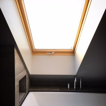 Badrum med walk-in shower, ångbad, snedtak och djupt takfönster.