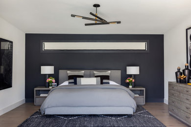 Diseño de dormitorio principal tradicional renovado grande con paredes grises, suelo de madera en tonos medios y suelo beige