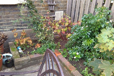 This is an example of a small contemporary courtyard formal partial sun garden for summer in Other with a garden path and brick paving.