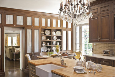 Eat-in kitchen - mid-sized traditional dark wood floor and brown floor eat-in kitchen idea in Los Angeles with a farmhouse sink, raised-panel cabinets, medium tone wood cabinets, quartz countertops, beige backsplash, subway tile backsplash, stainless steel appliances, an island and white countertops