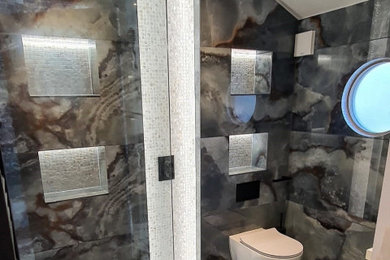 Diseño de cuarto de baño principal, único y flotante moderno de tamaño medio con armarios con paneles lisos, puertas de armario grises, sanitario de una pieza, suelo de baldosas de porcelana y suelo multicolor