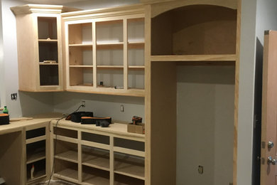 Example of a mid-sized trendy u-shaped kitchen pantry design in New Orleans with raised-panel cabinets and an island