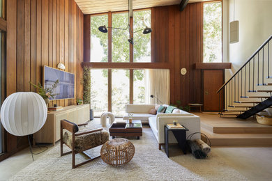 Inspiration for a mid-sized midcentury open concept living room in San Francisco with brown walls, porcelain floors, a wall-mounted tv, beige floor, wood and wood walls.