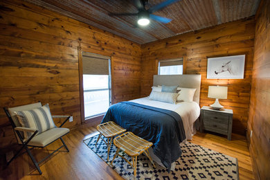Country guest carpeted and gray floor bedroom photo in Austin with brown walls