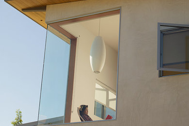 Inspiration for a large modern beige two-story stucco exterior home remodel in Los Angeles with a shed roof
