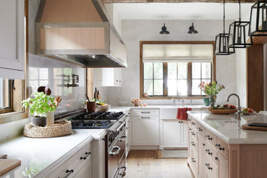Inspiration for a large country u-shaped light wood floor, brown floor and exposed beam eat-in kitchen remodel in Toronto with a farmhouse sink, white cabinets, gray backsplash, stone slab backsplash, colored appliances, an island and white countertops