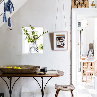Foto på en eklektisk entré, med vita väggar, ljust trägolv och en enkeldörr