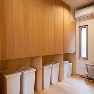 Inspiration for a medium sized country utility room in Other with beaded cabinets, medium wood cabinets, white walls, plywood flooring, an integrated washer and dryer and beige floors.