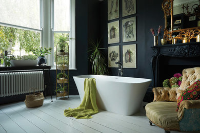Inspiration for a mid-sized contemporary kids bathroom in Other with a freestanding tub, black walls, light hardwood floors and white floor.