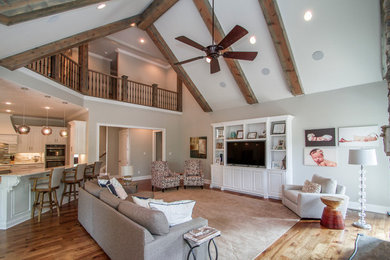 Large elegant open concept medium tone wood floor and beige floor living room photo in Little Rock with gray walls, a standard fireplace, a stone fireplace and a media wall