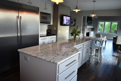 Open concept kitchen - mid-sized transitional dark wood floor open concept kitchen idea in Other with raised-panel cabinets, white cabinets, granite countertops, stainless steel appliances and an island
