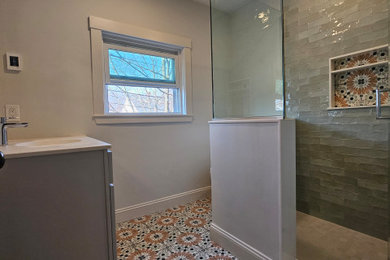 Inspiration for a mid-sized modern 3/4 gray tile and porcelain tile porcelain tile, multicolored floor and single-sink corner shower remodel in Boston with shaker cabinets, gray cabinets, a two-piece toilet, gray walls, an integrated sink, quartz countertops, a hinged shower door, white countertops and a freestanding vanity