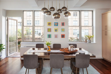 Cette image montre une salle à manger design avec un mur blanc, parquet foncé et un sol marron.