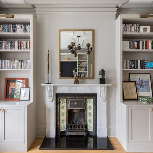 This is an example of a classic family and games room in London with white walls, medium hardwood flooring and brown floors.