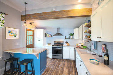 Example of a mid-sized country l-shaped medium tone wood floor enclosed kitchen design in Raleigh with an undermount sink, shaker cabinets, white cabinets, white backsplash, wood backsplash, stainless steel appliances and an island