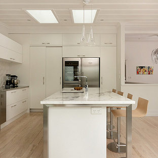Mid-sized contemporary kitchen pantry remodeling - Inspiration for a mid-sized contemporary galley light wood floor kitchen pantry remodel in Auckland with an undermount sink, flat-panel cabinets, white cabinets, marble countertops, white backsplash, ceramic backsplash, stainless steel appliances and an island