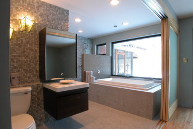 Inspiration for a contemporary bathroom in Chicago with flat-panel cabinets, dark wood cabinets, a drop-in tub, a two-piece toilet, multi-coloured tile, multi-coloured walls, a vessel sink, engineered quartz benchtops, beige floor and white benchtops.