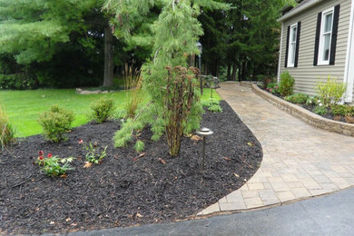 Inspiration for a mid-sized traditional side yard driveway in New York with a retaining wall and natural stone pavers.