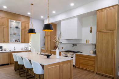 Example of a huge minimalist galley brown floor eat-in kitchen design in New Orleans with a drop-in sink, quartz countertops, multicolored backsplash, marble backsplash, white appliances, an island and white countertops
