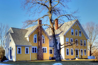 Inspiration for a mid-sized timeless yellow two-story wood exterior home remodel in Boston with a mixed material roof