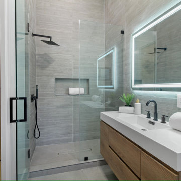 Backlit Mirror Over a Trough Basin Beside the Shower