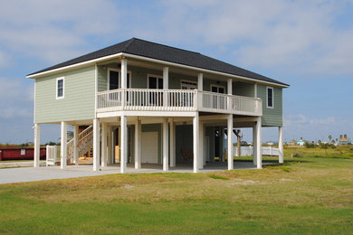 Inspiration for a mid-sized coastal green two-story wood exterior home remodel in Houston with a shingle roof