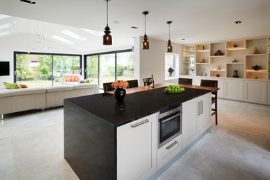 This is an example of a contemporary l-shaped open plan kitchen in Kent with quartzite benchtops and with island.