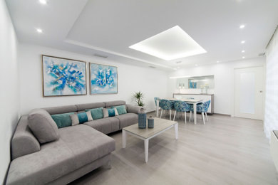 Ejemplo de salón cerrado moderno de tamaño medio con paredes blancas, suelo de baldosas de porcelana, televisor colgado en la pared, suelo gris y bandeja