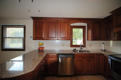 Eat-in kitchen - mid-sized traditional u-shaped terra-cotta tile eat-in kitchen idea in Cleveland with dark wood cabinets, white backsplash, stainless steel appliances, no island, a double-bowl sink, raised-panel cabinets, laminate countertops and subway tile backsplash