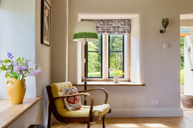 Inspiration for a medium sized bohemian open plan living room in Gloucestershire with terracotta flooring, white walls, a built-in media unit and brown floors.