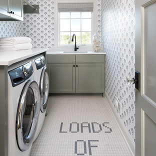 ミネアポリスのトラディショナルスタイルのおしゃれなランドリールーム (シングルシンク、シェーカースタイル扉のキャビネット、グレーのキャビネット、マルチカラーの壁、左右配置の洗濯機・乾燥機、マルチカラーの床、白いキッチンカウンター) の写真