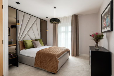 Medium sized contemporary master bedroom in Kent with beige walls, carpet, beige floors and wallpapered walls.