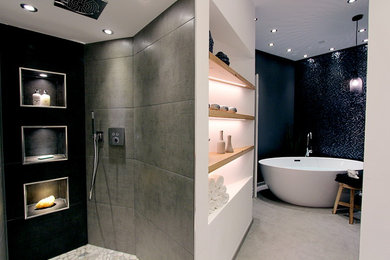 Trendy gray tile and mosaic tile pebble tile floor bathroom photo in Other with gray walls
