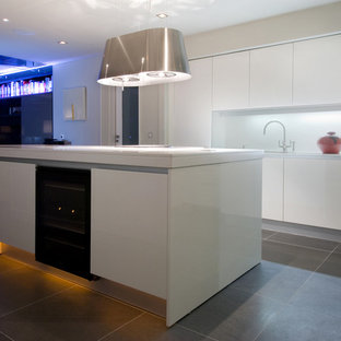 Mid-sized contemporary kitchen pantry designs - Mid-sized trendy limestone floor kitchen pantry photo in Dublin with a double-bowl sink, flat-panel cabinets, white cabinets, quartz countertops, white backsplash, glass sheet backsplash, black appliances and an island