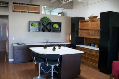 Trendy l-shaped medium tone wood floor and brown floor eat-in kitchen photo in Denver with an undermount sink, flat-panel cabinets, dark wood cabinets, quartzite countertops, brown backsplash, stainless steel appliances and an island