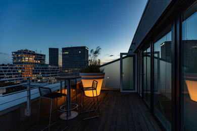 Imagen de terraza contemporánea grande en azotea con jardín de macetas, toldo y barandilla de metal