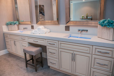 Example of a large transitional master limestone floor bathroom design in Miami with raised-panel cabinets, light wood cabinets, an integrated sink, concrete countertops and gray walls