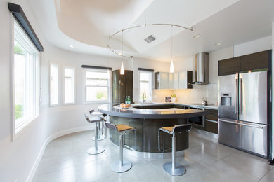 Mid-sized trendy u-shaped porcelain tile and gray floor open concept kitchen photo in San Francisco with an undermount sink, flat-panel cabinets, dark wood cabinets, quartz countertops, white backsplash, stainless steel appliances and a peninsula