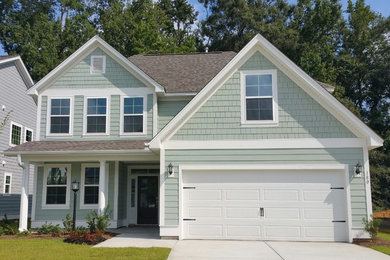 Mid-sized elegant green two-story wood exterior home photo in Charleston with a shingle roof