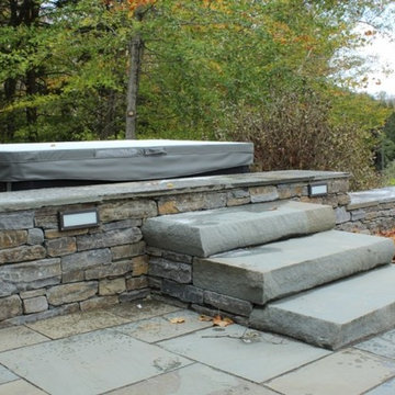 Bluestone steps and stepped up wall provide hot tub access