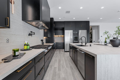 Inspiration for a large contemporary gray floor eat-in kitchen remodel in Los Angeles with an undermount sink, flat-panel cabinets, black cabinets, quartz countertops, gray backsplash, stone slab backsplash, stainless steel appliances and gray countertops
