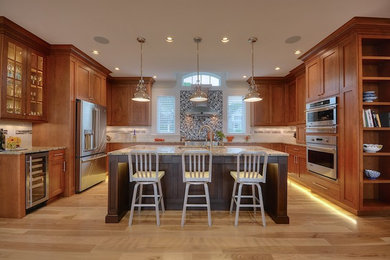 Inspiration for a mid-sized traditional u-shaped separate kitchen in New York with an undermount sink, shaker cabinets, medium wood cabinets, granite benchtops, white splashback, subway tile splashback, stainless steel appliances, light hardwood floors, with island, beige floor and beige benchtop.