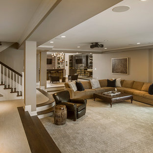 Photo of an expansive shabby-chic style walk-out basement in Cincinnati with beige walls, dark hardwood flooring, a standard fireplace, a stone fireplace surround and brown floors.