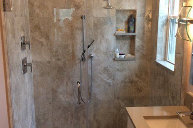 This is an example of a mid-sized contemporary bathroom in Tampa with an undermount sink, flat-panel cabinets, white cabinets, engineered quartz benchtops, a curbless shower, a two-piece toilet, beige tile, porcelain tile, grey walls and porcelain floors.