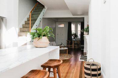 This is an example of a kitchen in Sydney with marble benchtops and medium hardwood floors.