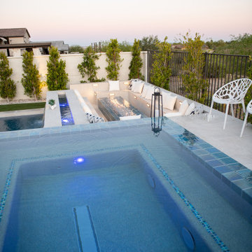 Raised, "rimflow" spa with sunken fire pit area