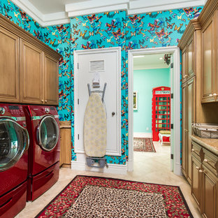 ロサンゼルスの地中海スタイルのおしゃれな洗濯室 (レイズドパネル扉のキャビネット、中間色木目調キャビネット、マルチカラーの壁、左右配置の洗濯機・乾燥機、ベージュの床) の写真