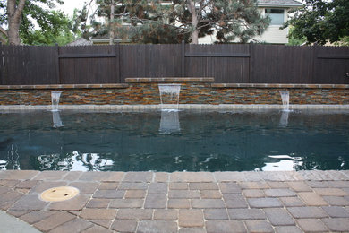 This is an example of a large arts and crafts backyard rectangular lap pool in Boise with a water feature and brick pavers.