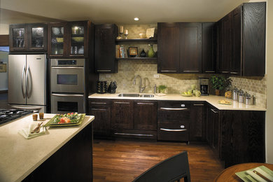 Photo of a large transitional l-shaped eat-in kitchen in Other with an undermount sink, recessed-panel cabinets, dark wood cabinets, stainless steel appliances, medium hardwood floors, with island, beige splashback and brown floor.