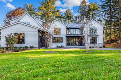 Inspiration for a large cottage white exterior home remodel in Boston with a metal roof and a black roof